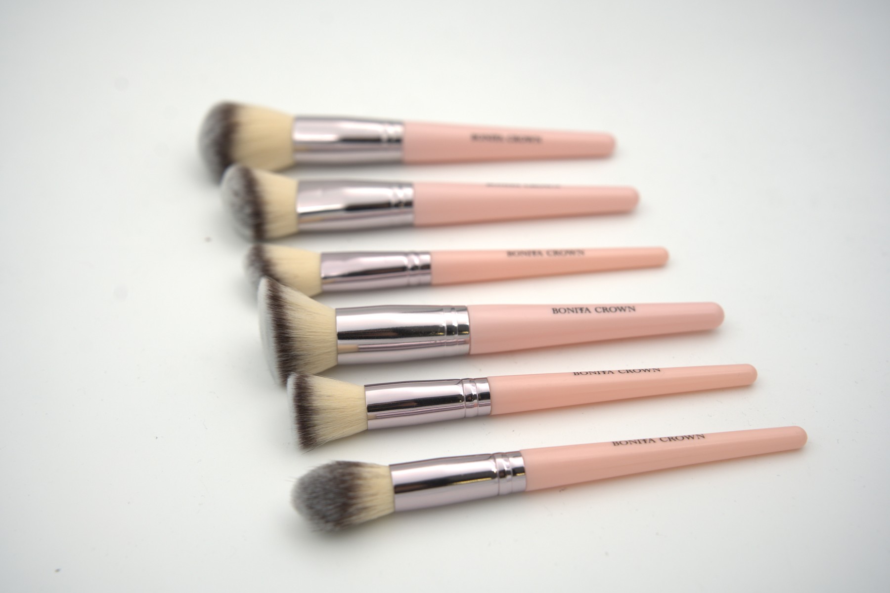 Close-up of Bonita Crown face makeup brushes with pink handles